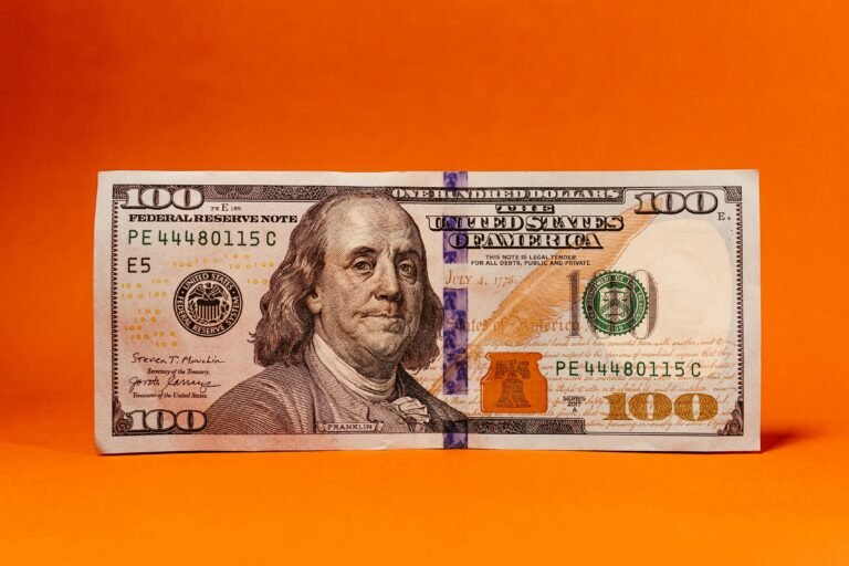 Close-up of a One Hundred Dollar Bill with an Orange Background